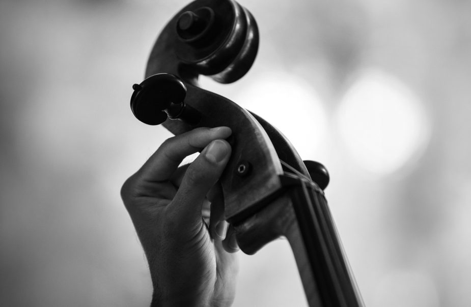 hand stämmer skruvar på en cello